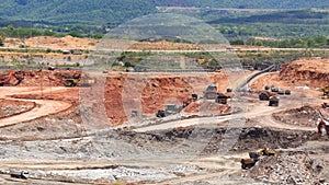 Zoom out mining dump trucks and excavators