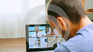 Zoom out shot of man on a video call