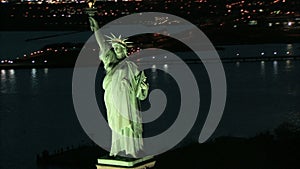 Zoom out from statue of liberty night aerial