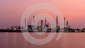 Zoom out Time lapse of Oil refinery at the river in sunrise time