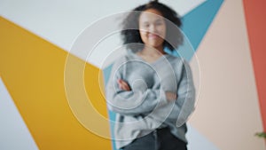 Zoom-in portrait of attractive African-American girl standing indoors smiling