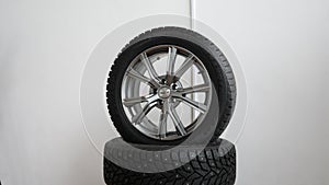 Zoom in shot of new rubber tire in dealership office on white background. Tracking shot of new modern car tyre for