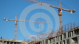 Zoom Time lapse tilt shift builders and industrial cranes work on construction