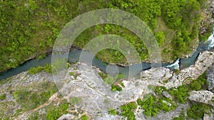Zoomed aerial video of river, going through it's canyon, full of green vegetations