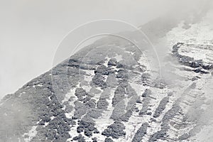 Zoomed Alps mountain covered with fresh snow fall, snow falling photo