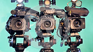 Zooming-in footage of three camcorders in a studio