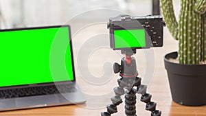 Zooming out footage on camera with chromakey screen on tripod