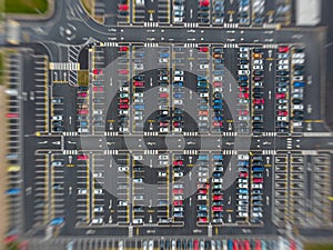 Zooming in from space on large modern carpark with symmetrical roads rows of parking bays lots of symmetry and colours aerial view