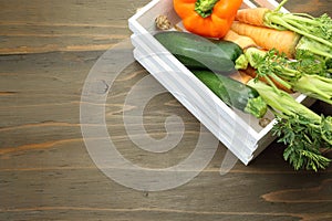 Zucchini and carrot in a white wooden container