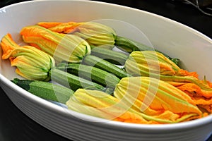 Zucchini or courgette flowers stuffed with cheese in a casserole dish