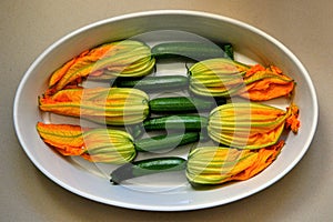 Zucchini or courgette flowers stuffed with cheese in a casserole dish