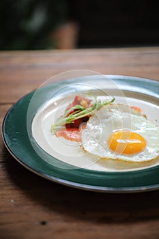 Zucchini fritters with egg and smoked salmon on wood background vinage style