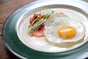 Zucchini fritters with egg and smoked salmon on wood background vinage style