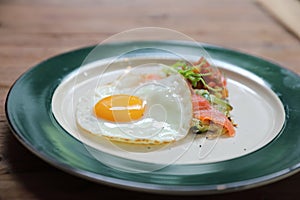 Zucchini fritters with egg and smoked salmon on wood background vinage style
