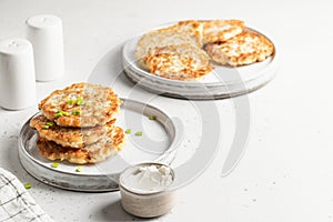 Zucchini fritters sprinkled with green onions with salt and pepper shaker and checkered napkin. Text space