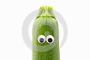 Zucchini with googly eyes on white background