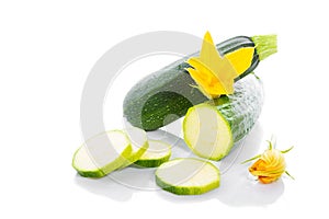 Zucchini or green marrow squash with green leaves and flowers isolated