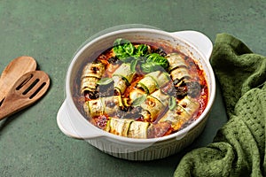 Zucchini lasagna rolls stuffed with ricotta, baked in tomato sauce.