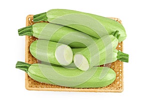 zucchini or marrow in a wicker basket isolated on white background with full depth of field. Top view. Flat lay