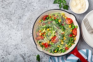 Zucchini noodle with tomato, corn and green peas on pan, healthy vegan food