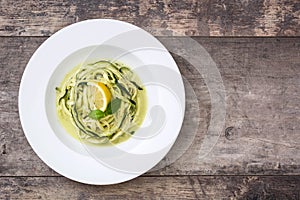 Zucchini noodles with pesto sauce on wooden table