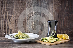 Zucchini noodles with pesto sauce on wooden table