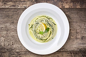 Zucchini noodles with pesto sauce on wooden table