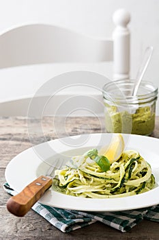 Zucchini noodles with pesto sauce on wooden table