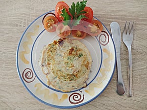 Zucchini pancake with cherry tomato on plate