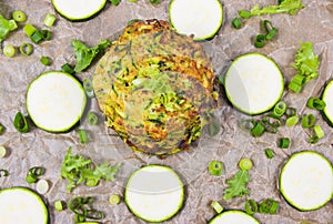 Zucchini pancakes with chives on a wooden table