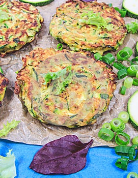 Zucchini pancakes with chives on a wooden table