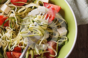 Zucchini pasta with feta and tomatoes macro. horizontal top view