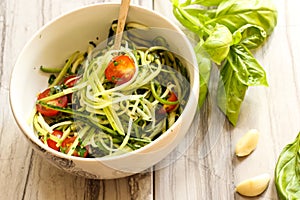 Zucchini pasta noodles with dressing in a white bowl