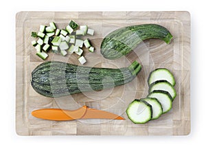 Zucchini sliced and chopped on wooden cutting board with knife f