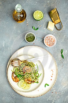 zucchini spaghetti Pasta with basil pesto sauce and grilled shrimp, Vegetarian healthy food, place for text, top view