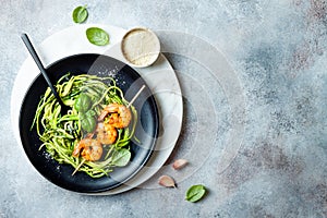 Zucchini spaghetti with pesto sauce and grilled shrimp skewers. Vegetarian vegetable low carb pasta. Zucchini noodles or zoodles.