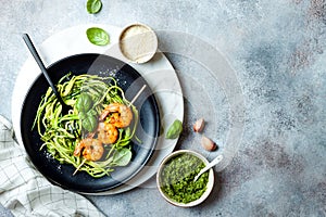 Zucchini spaghetti with pesto sauce and grilled shrimp skewers. Vegetarian vegetable low carb pasta. Zucchini noodles or zoodles.