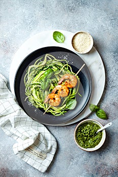 Zucchini spaghetti with pesto sauce and grilled shrimp skewers. Vegetarian vegetable low carb pasta. Zucchini noodles or zoodles.