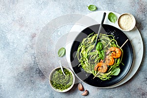 Zucchini spaghetti with pesto sauce and grilled shrimp skewers. Vegetarian vegetable low carb pasta. Zucchini noodles or zoodles.