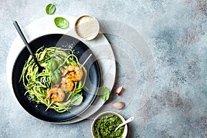 Zucchini spaghetti with pesto sauce and grilled shrimp skewers. Vegetarian vegetable low carb pasta. Zucchini noodles or zoodles.