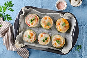 Zucchini stuffed with minced meat and rice, with tomatoes and mozzarella