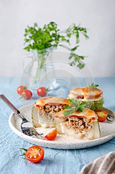 Zucchini stuffed with minced meat and rice, with tomatoes and mozzarella