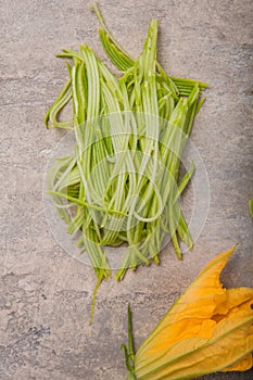 Zucchini vegetable noodles - green zoodles or courgette spaghetti on plate over gray background. Clean eating, raw vegetarian food