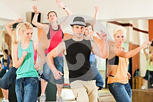 Zumba or Jazzdance - young people dancing in studio