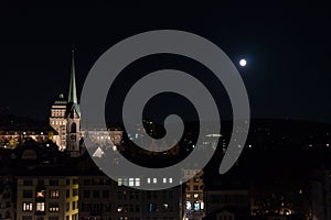 Zurich city by night with full moon shinging and light on buildings