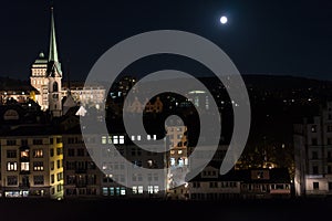 Zurich city by night with full moon shinging and light on buildings