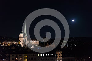 Zurich city by night with full moon shinging and light on buildings