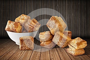 Bunch Of Zuzu Square Sesame Puff Croissant Pastry Set On Rustic Bamboo Place Mat