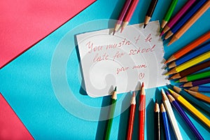 Â«You mustn`t be late for schoolÂ», - note for a schoolboy from a loving mother lies next to the colored pencils
