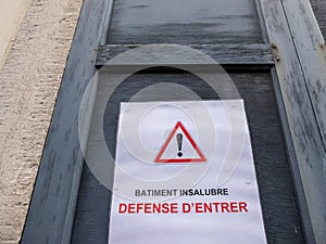 ÃÂ«Batiment insalubre, dÃÂ©fense dÃ¢â¬â¢entrerÃÂ», ÃÂ«Insanitary building, forbidden to enterÃÂ» poster with a warning sign